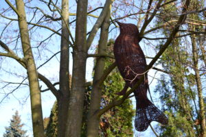 Ptak wykonany z wikliny umocowany na gałęzi drzewa