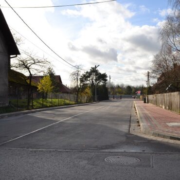 Przebudowana ulica z nowym chodnikiem po prawej stronie, oraz nową nawierzchnią asfaltową