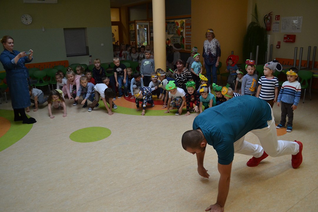 Olimpijczyk Bartłomiej Stój pokazuje ćwiczenia dzieciom w przedszkolu